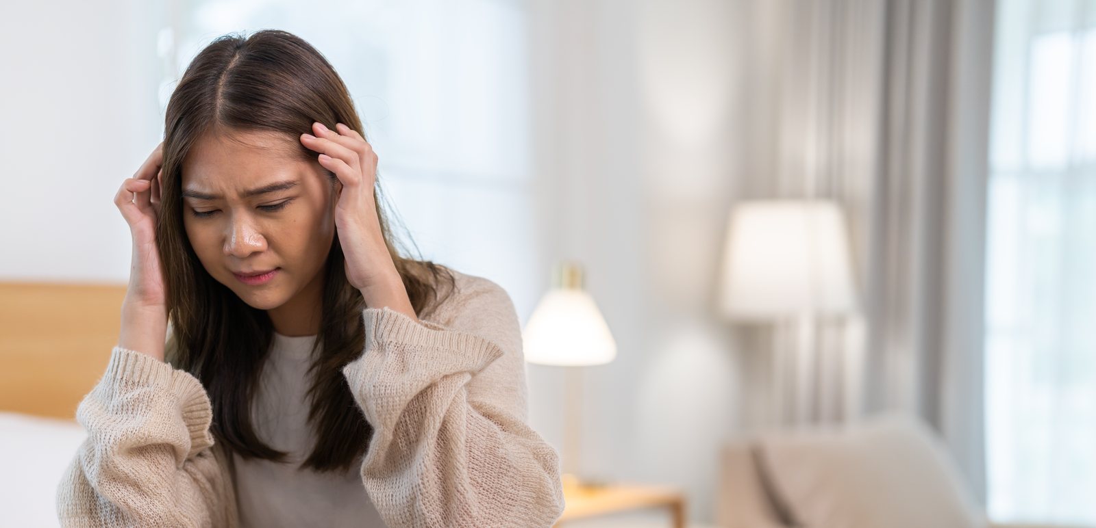A woman holding her head in discomfort